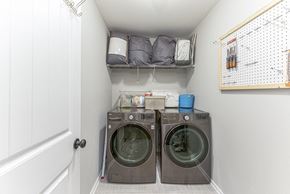 Clarksville house for rent - a small laundry room with a washer and dryer and a shelf above it