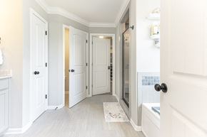Clarksville house for rent - a renovated bathroom with white doors and a walk in shower