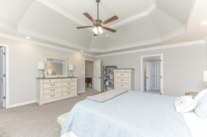 Clarksville house for rent - a bedroom with a large bed and a ceiling fan