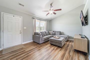 Jacksonville house for rent - A living room with a grey couch and a wooden floor.