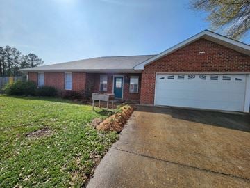Deridder house for rent - a house with a driveway and a white garage door