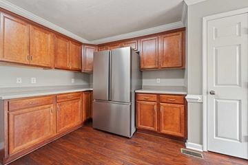 Jacksonville house for rent - A kitchen with wooden cabinets and a stainless steel refrigerator.