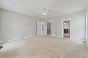 Jacksonville house for rent - A spacious room with a carpeted floor and a ceiling fan.