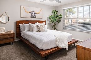 Robinsonville apartment for rent - A bedroom with a bed, a mirror, a dresser, and a plant.