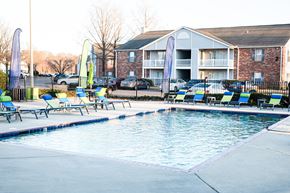 Walls apartment for rent - a swimming pool with chairs and a building in the background