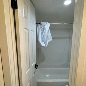 Phoenix apartment for rent - a bathroom with a white shower and a towel hanging from the door