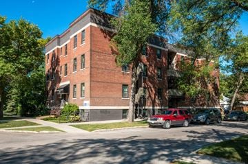 Winnipeg apartment for rent - a red brick building with cars parked in front of it