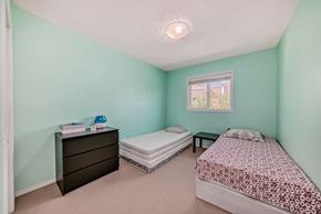 Edmonton house for rent - a bedroom with two beds and a dresser and a window
