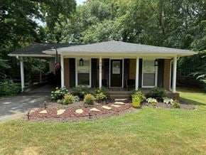 Charlotte house for rent - a front porch with a flower bed in front of a house