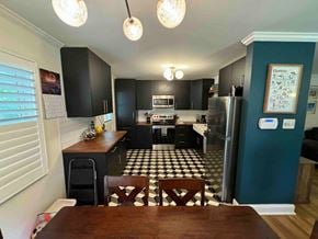 Charlotte house for rent - a kitchen with black cabinets and a checkered floor