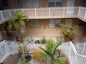 Homestead apartment for rent - an aerial view of a building with a balcony and palm trees