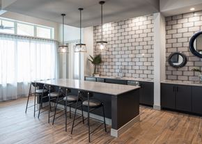 Houston apartment for rent - a kitchen with an island and chairs in front of a brick wall