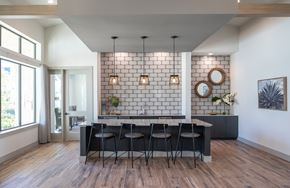 Houston apartment for rent - a dining room with a black table and chairs and a white brick wall