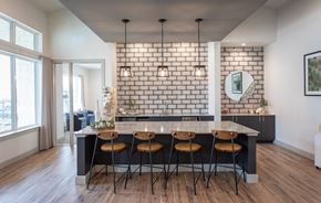 Cypress apartment for rent - a kitchen with a white brick accent wall and a marble counter top