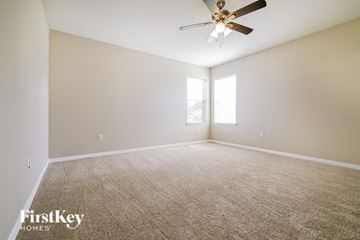 Lakeland house for rent - a spacious living room with carpet and a ceiling fan