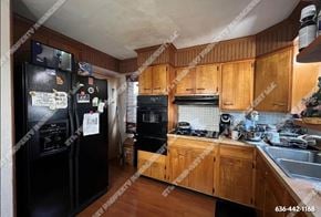 St. Louis house for rent - a kitchen with black appliances and wooden cabinets