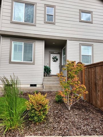 Tigard apartment for rent - A house with a grey siding and a white door with a wreath on it.