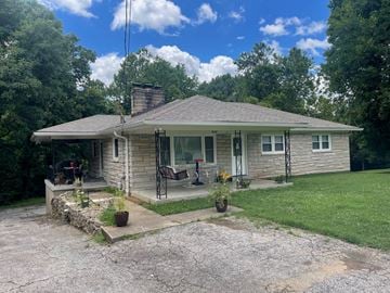 Louisville house for rent - A house with a grey roof and a stone wall in front.