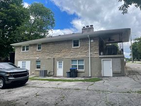 Louisville house for rent - A black car is parked in front of a two-story house.