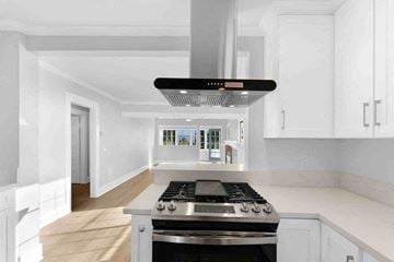 Fillmore house for rent - A modern kitchen with a stove top oven and white cabinets.