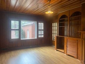 Greenwood house for rent - an empty living room with wood floors and a large window
