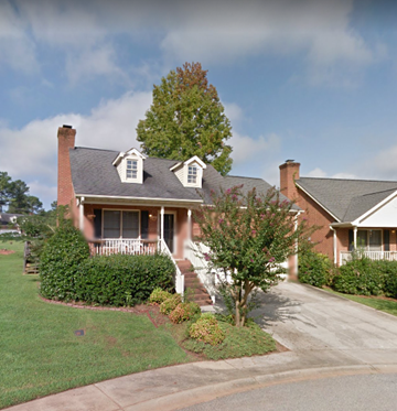 Greenwood house for rent - a house with a porch and a tree in front of it