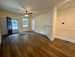 Greenville house for rent - a living room with wood floors and a ceiling fan