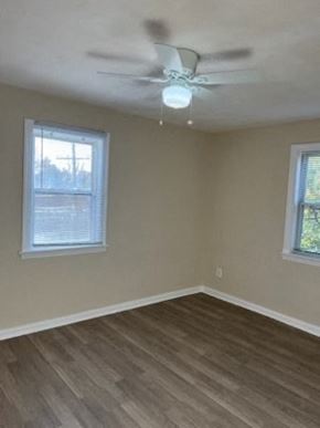 Washington apartment for rent - an empty room with a ceiling fan and two windows