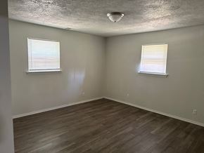 Newalla house for rent - A room with wooden flooring and two windows.