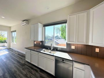 San Diego apartment for rent - A modern kitchen with white cabinets and a dark countertop.