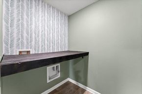 Southport house for rent - the lower level living room has a large window and a long wooden shelf