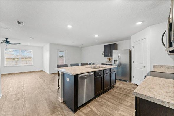 Southport house for rent - a kitchen with an island and a stainless steel refrigerator