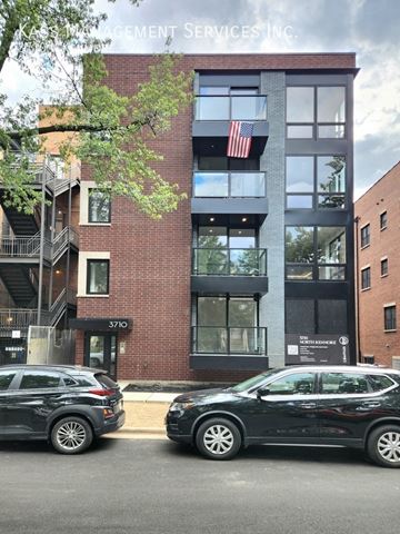 Chicago apartment for rent - Two black cars are parked in front of a building with a sign that reads "ACCEPTANCE SERVICES INC.".