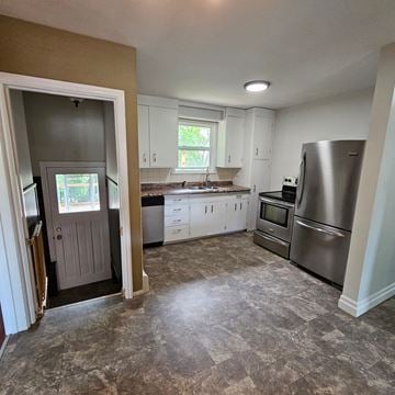 Sault Ste. Marie house for rent - a kitchen with white cabinets and stainless steel appliances