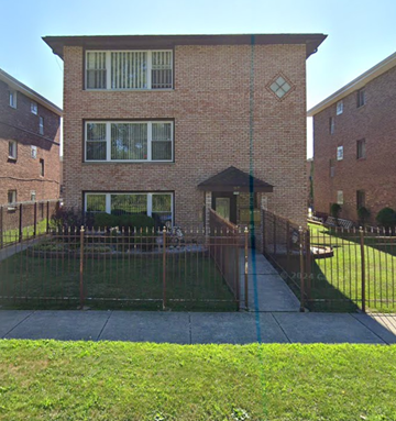 Calumet City apartment for rent - A brick house with a black fence and a small garden in front.