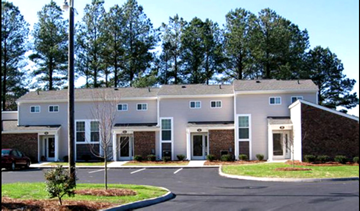 Four Oaks apartment for rent - an office building with a parking lot and trees