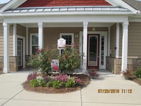 Lancaster apartment for rent - a front porch with flowers and a sign in front of a house