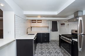 Denver apartment for rent - a kitchen with black and white tiles and a stove and a sink