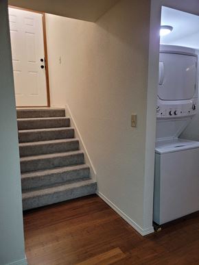 Tacoma apartment for rent - a stairway leading up to a bathroom with a washing machine and a dryer