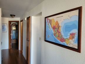 Tacoma apartment for rent - a map hangs on the wall in a hallway of a house