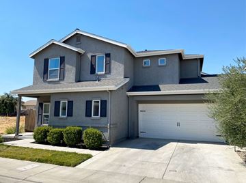 Merced house for rent - a house with a white garage door in front of a driveway