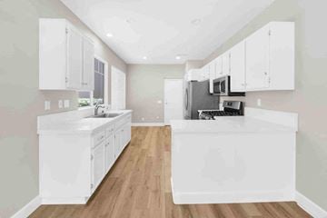 Aliso Viejo apartment for rent - an open kitchen with white cabinets and a sink and a microwave