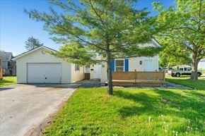 Trenton, Quinte West apartment for rent - A house with a white garage door and a blue window.
