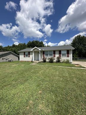 Clarksville house for rent - a white house with a yard and a blue sky with clouds