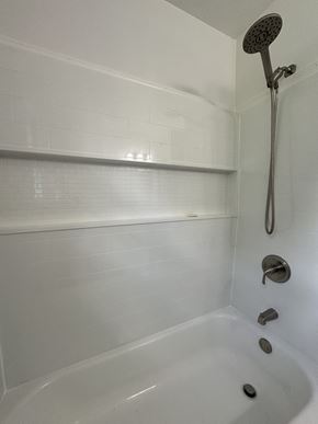 Clarksville house for rent - a white bathtub with a shower in a bathroom