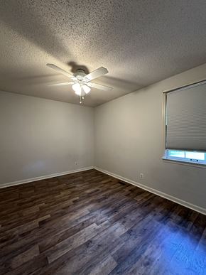 Clarksville house for rent - an empty living room with a ceiling fan and a window