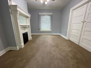 Louisville apartment for rent - a bedroom with a carpeted floor and a fireplace