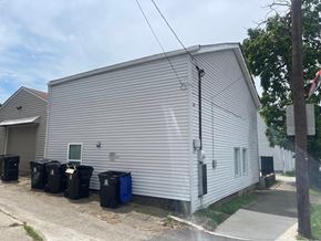 Louisville apartment for rent - the side of a building with trash cans in front of it