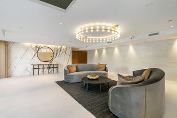 Los Angeles apartment for rent - A modern living room with a grey sofa, a round table, and a hanging light fixture.