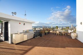 Los Angeles apartment for rent - A patio with a table and chairs overlooking a city.
